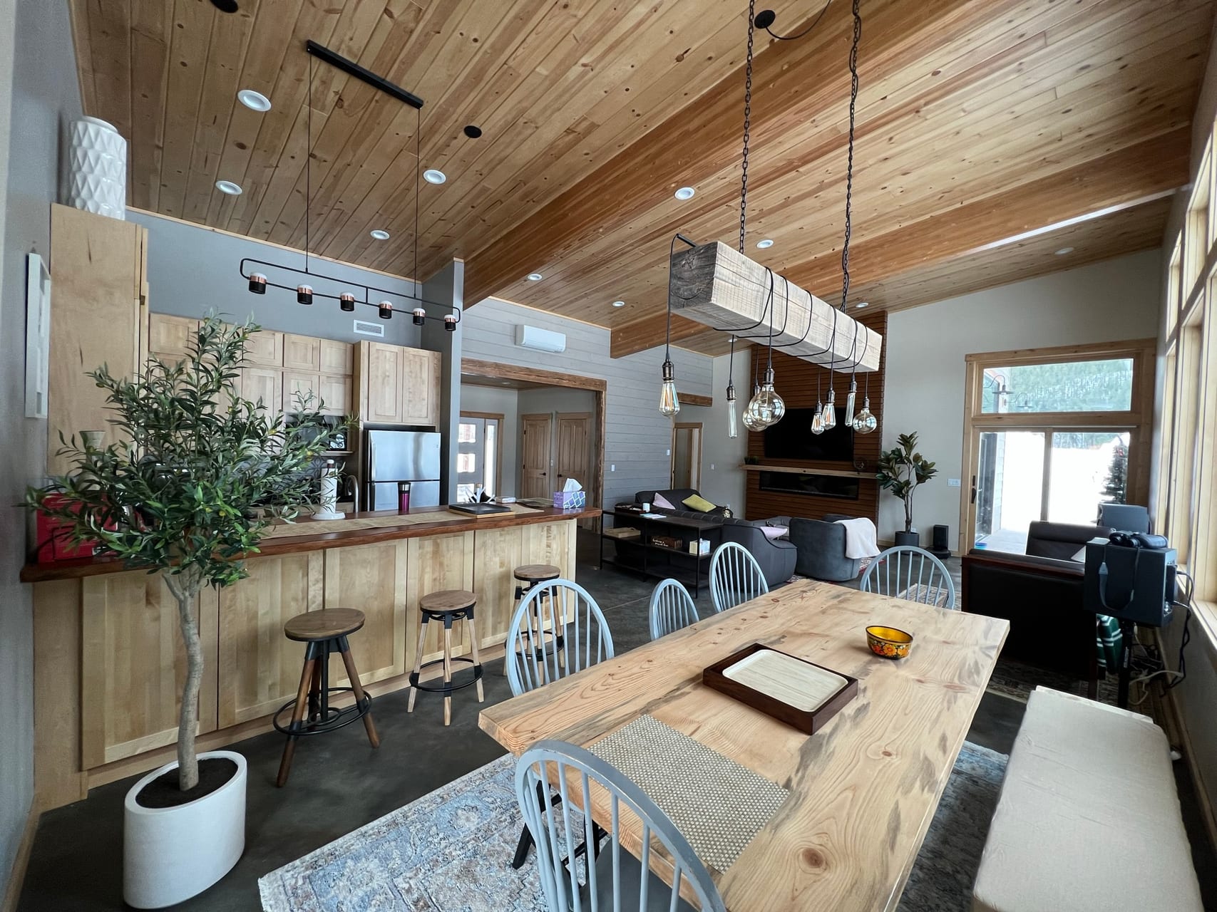 Reclaimed-wood dining table with Windsor chairs and Edison-bulb pendant light