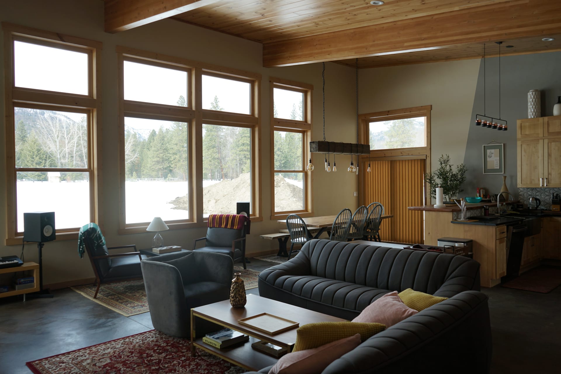 Great room with floor-to-ceiling windows overlooking snowy mountain meadow