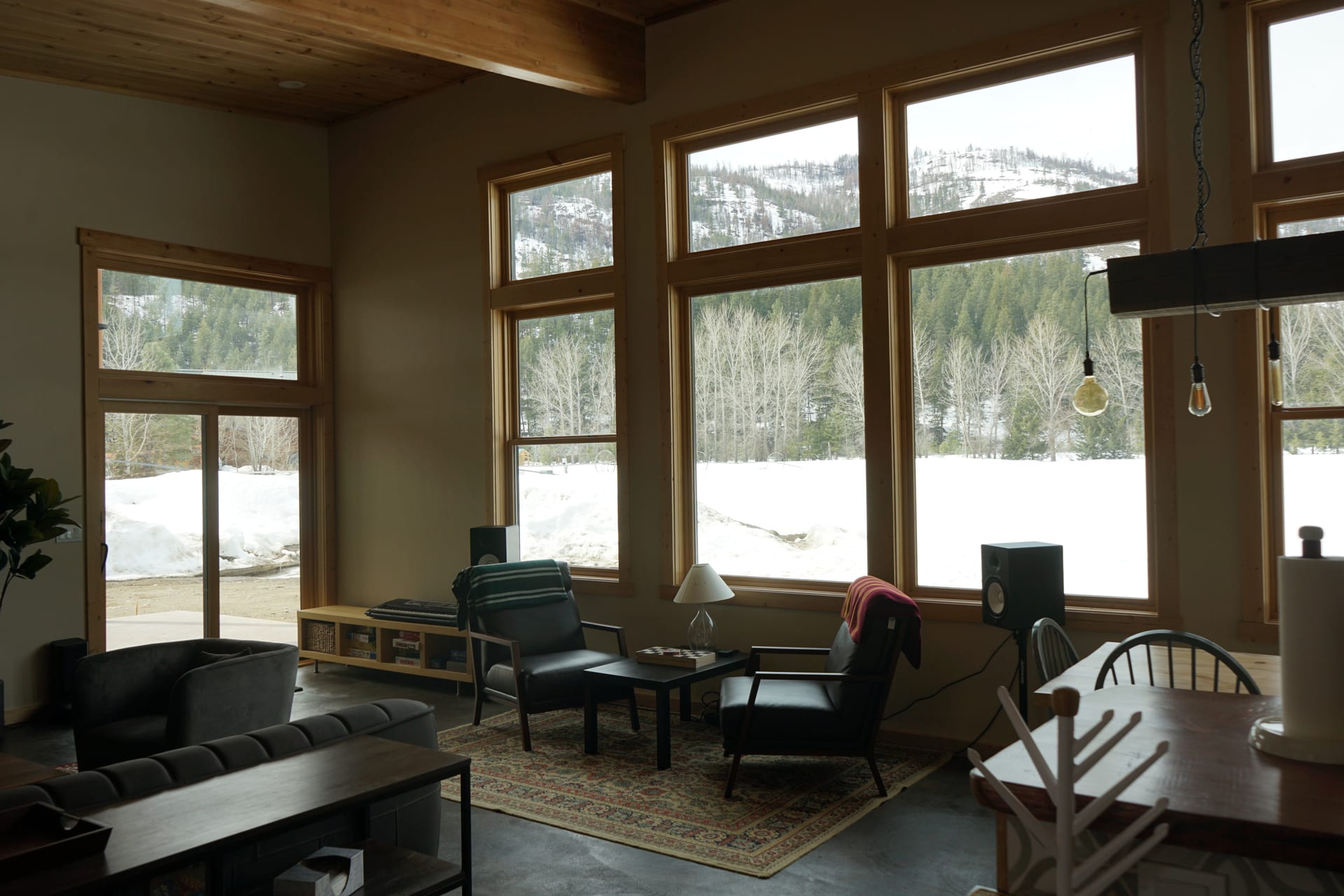 Panoramic mountain view through large wood-framed windows