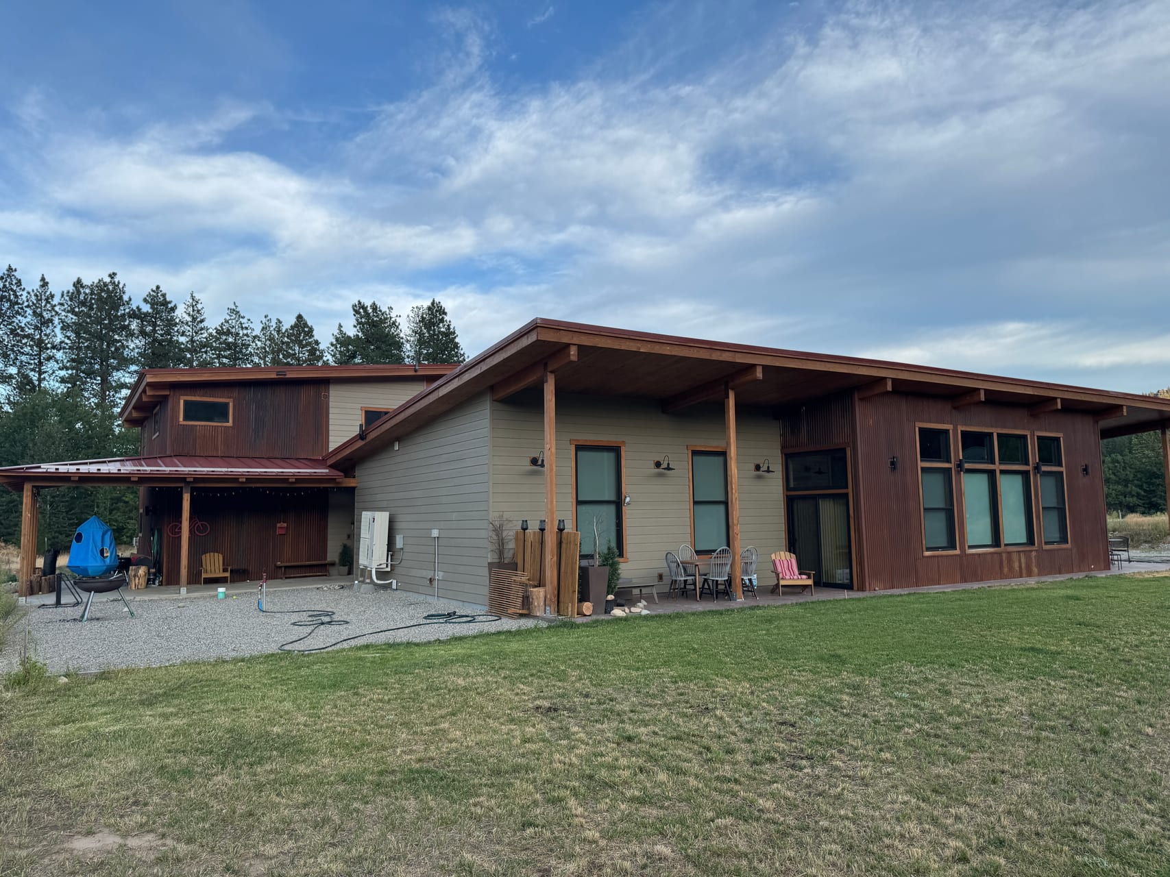 Lodge in summer with green lawn and outdoor seating on the patio
