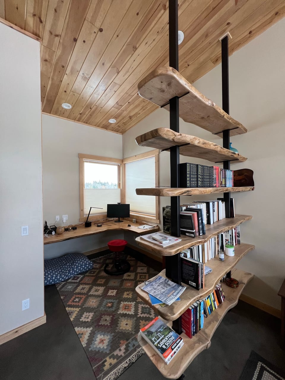 Writing nook with live-edge shelves, books, and natural light