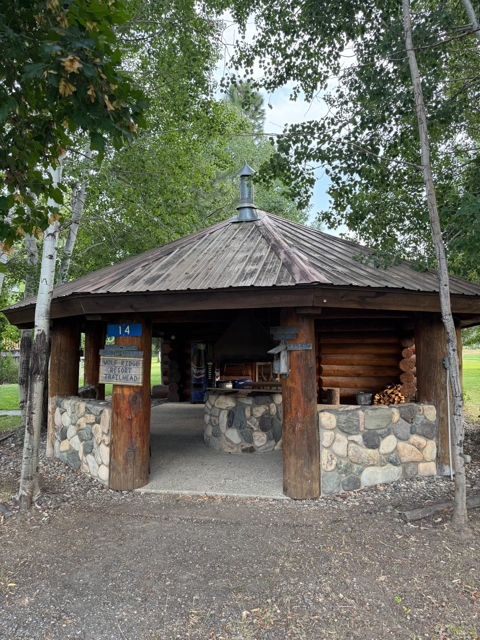 Warming hut stone chimney with log timbers and birch trees