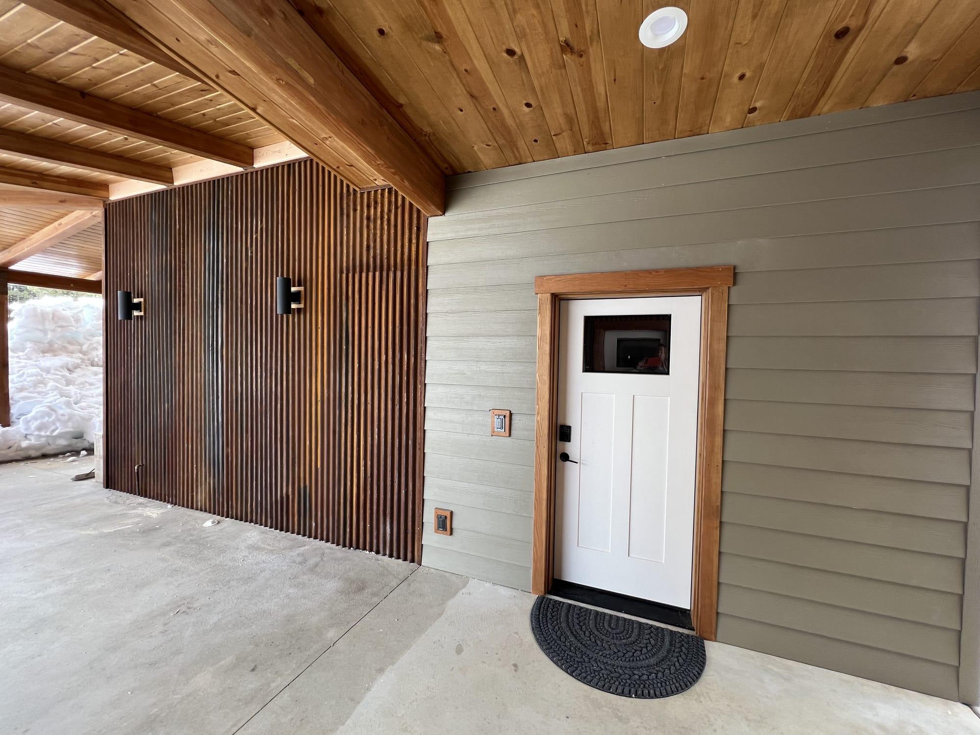 The apartment entry, under the cedar-slat wall of the covered walkway